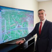 Man in suit beside map of world.