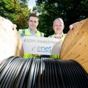 Two men with a reel of fibre.