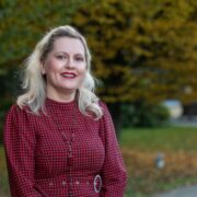Fair haired woman in red dress.