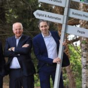 Three men in suits and woman in red coat.