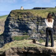 Woman standing on cliffs in rural Ireland.