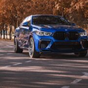 Blue BMW in autumnal forest.