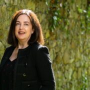 Dark-haired woman in dark coat.