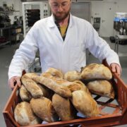 Man holding a batch of bread.