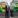 Two bearded men standing in front of green and yellow buses.