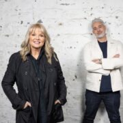 Man and woman standing in front of a white wall.