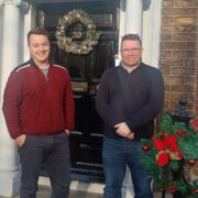 Two men in front of a door.