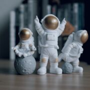 three toy astronauts on a table.