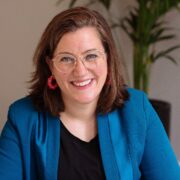 Smiling woman in blue blazer.