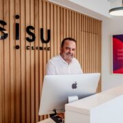 Man standing at reception at a Sisu Clinic.