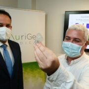 Two men looking at a medical device.