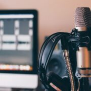 Podcast studio with computer, mic and headphones.