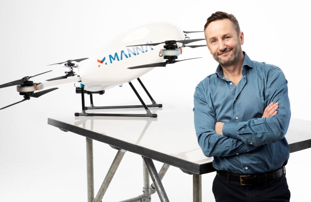 Man in blue shirt in front of a drone.
