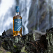Bottle of Irish whiskey beside a waterfall.
