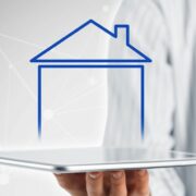 Shape of house emerging from a digital device.