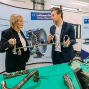 Man and woman examine aircraft parts.