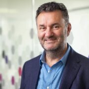 Man in blue shirt, navy blazer.