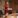 Woman in red dress addressing a boardroom.