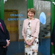 Two men and a woman outside a building.