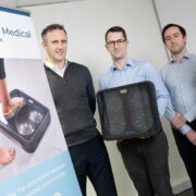 Three men and a woman with a medical device.