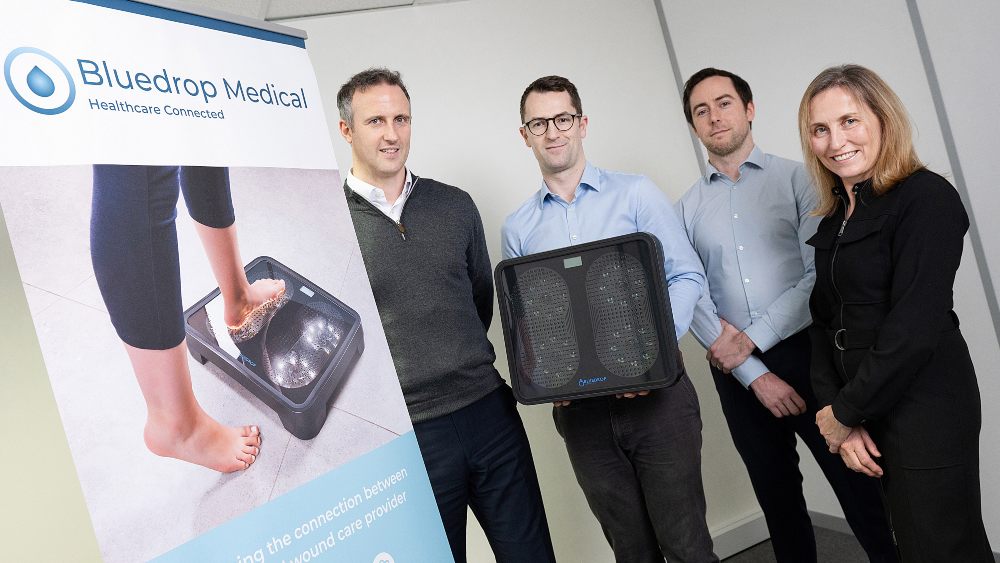 Three men and a woman with a medical device.