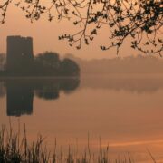 Sun setting on a lake with a castle in Cavan.