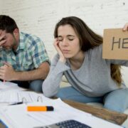 Business owners struggling with accounts holding up a help sign.