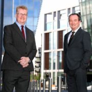 Two men outside glass buildings in Dublin.