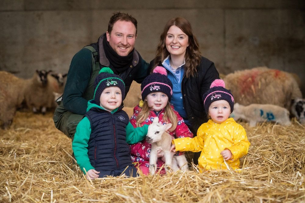 Farming family with a lamb.