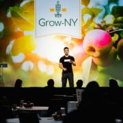 Man pitching on stage at Grow-NY start-up competition for agtech businesses.