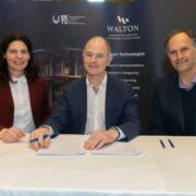 Woman and two men sitting at a table.