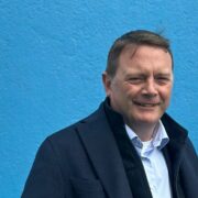 Man in front of blue wall.