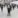 Group of people standing in front of aircraft in a hangar.