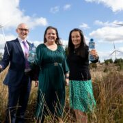 Man and two woman at a wind farm.