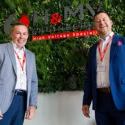 Two smiling men in suits.