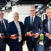 Four men cutting a ribbon.