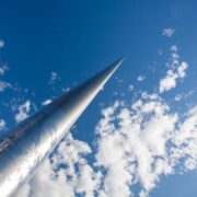 Spire in Dublin reaches into a blue sky with a few clouds.
