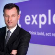 Man in suit standing in front of Expleo sign.