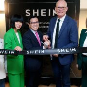 Group of people cutting a ribbon.