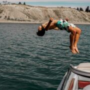 Man doing a backflip into the sea.