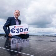 Man holding sign on a solar roof.