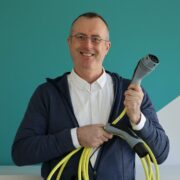 Man holding electric vehicle charging cable.