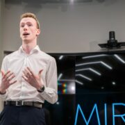 Man in white shirt speaking.