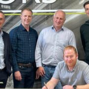 Four men standing and one sitting.