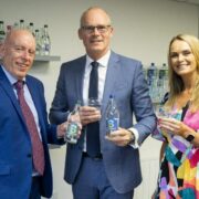 Two men and a woman holding water bottles.