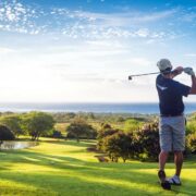 Man teeing off on a golf course.