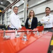 Two men and a woman inside a factory.
