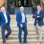 Three men standing on steps.