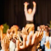 People raising hands at an event.