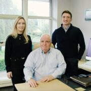 A woman and two men in an office.
